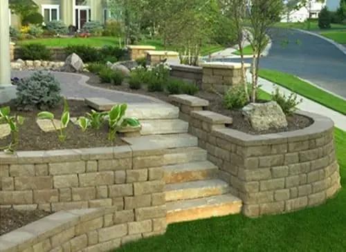 Perimeter grade retaining wall securing driveway hillside